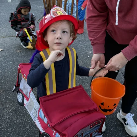 Child dressed as a firefighter at a Halloween event