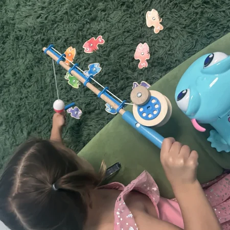 Child practicing coordination with a magnetic fishing game