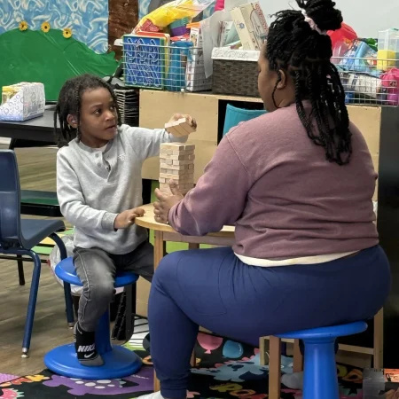 Therapist and child working together on a block-stacking activity