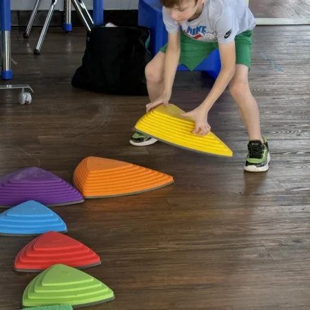 Child arranging colorful stepping stones during a motor activity