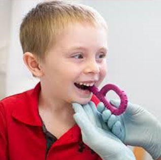 Child in a red shirt during a feeding therapy session