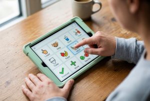 Person using an AAC communication app on a tablet