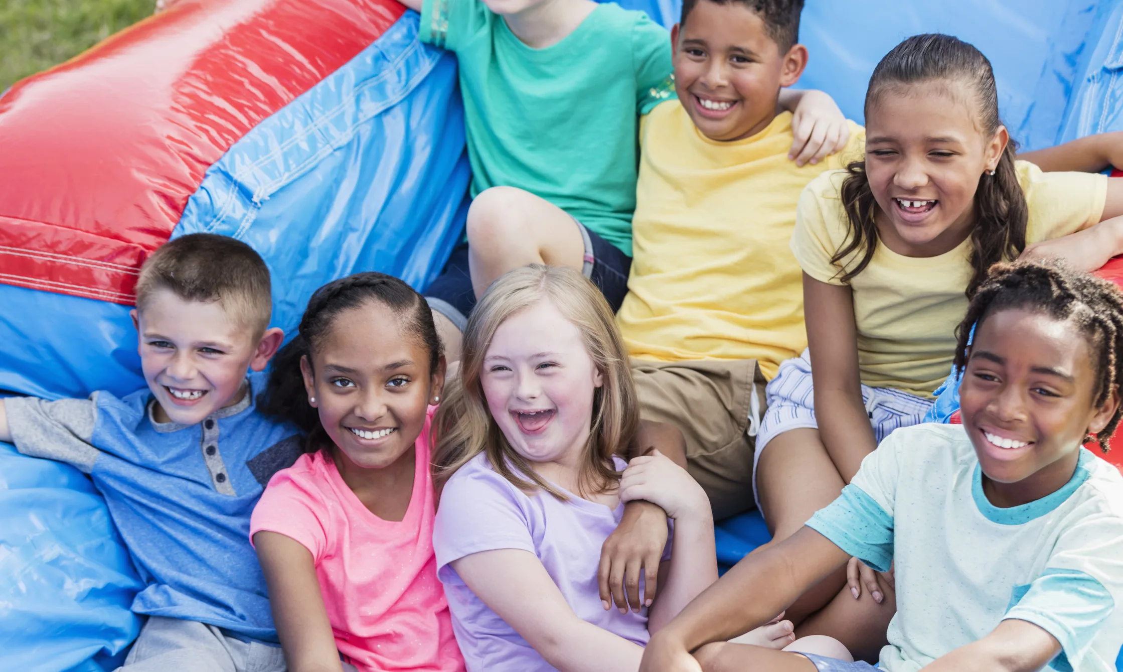 Kids smiling on an inflatable