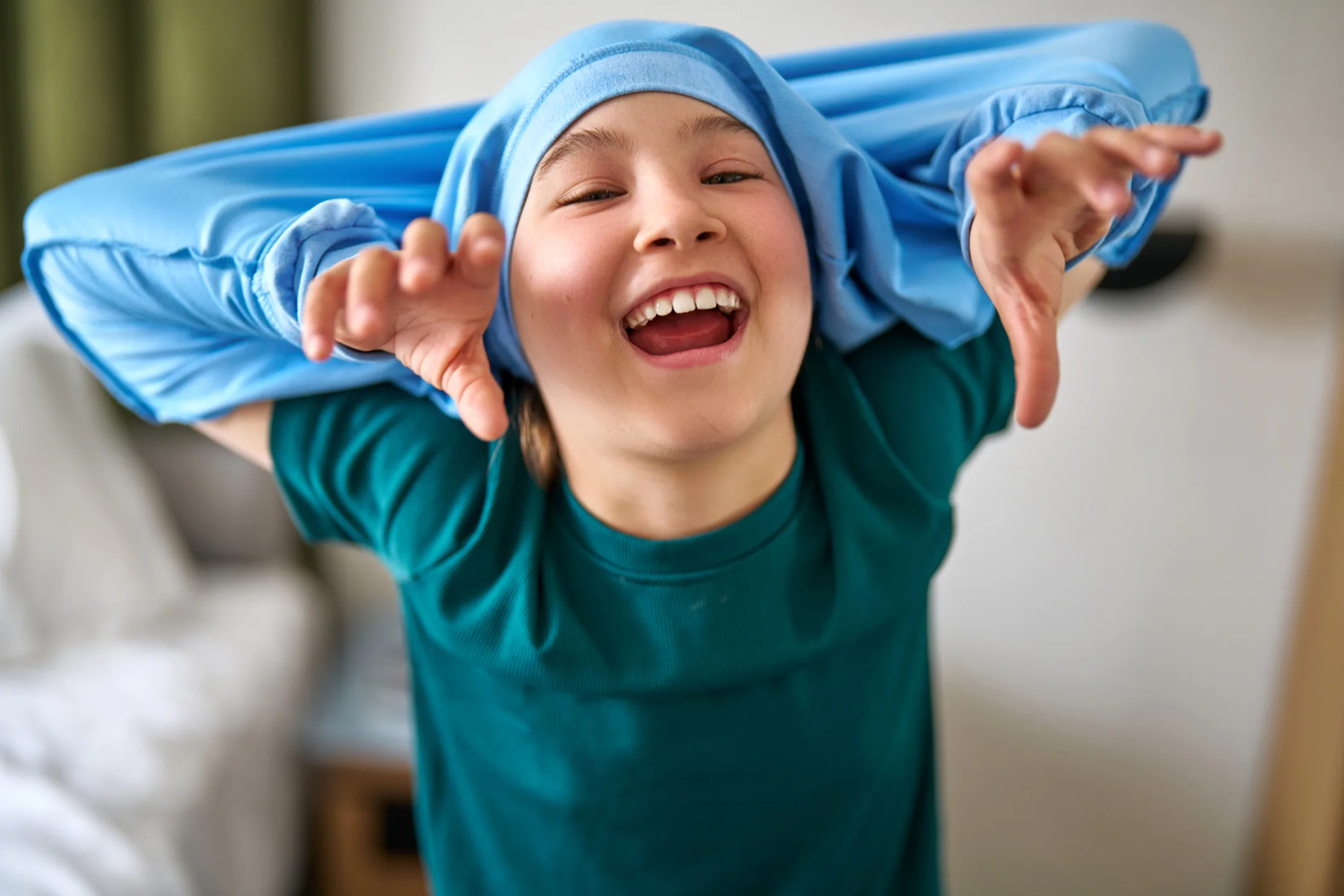 Laughing child playing with a stretchy fabric over their head